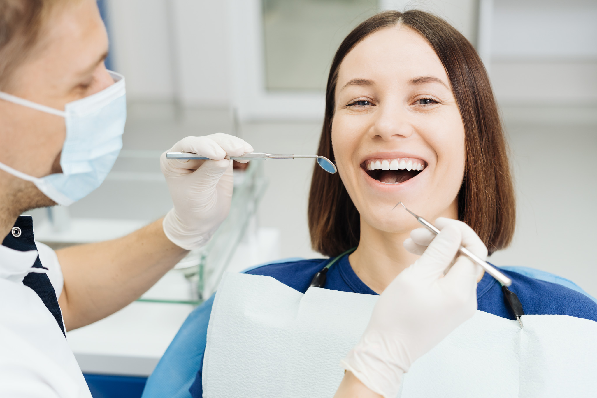 Dentist check patient cavity using instruments at clinic